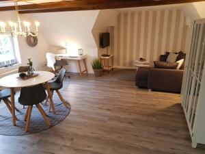 a living room with a table and a couch at Neu renovierte Ferienwohnung mit Poolhaus & Sauna auf dem Bauernhof in Oetzen