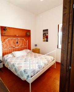 1 dormitorio con cama blanca y cabecero de madera en Villetta Punta Granata Santa Marina Salina, en Santa Marina Salina