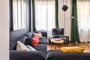 a living room with a blue couch with pillows at Studio of Liberty in Paris