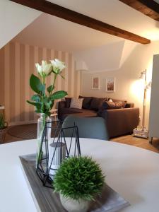 a vase of flowers on a table in a living room at Neu renovierte Ferienwohnung mit Poolhaus & Sauna auf dem Bauernhof in Oetzen