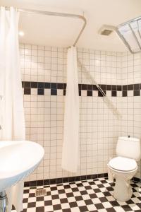 Łazienka z białą toaletą i umywalką w obiekcie Hotelroom Villa 1913 w mieście Bergen