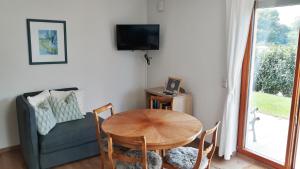 ein Wohnzimmer mit einem Tisch, einem Sofa und einem TV in der Unterkunft Komfort Appartement Panoramaweg in Waldenbuch