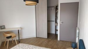 um quarto com uma secretária, uma mesa e um espelho em T2 55m2 Perpignan proche centre ville et gare avec parking em Perpignan