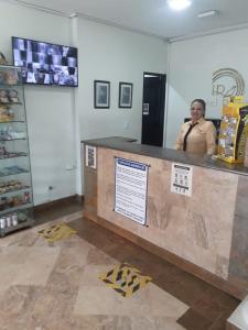 a man standing at the counter of a doughnut shop at Hotel Ruiseñor Itagui in Itagüí