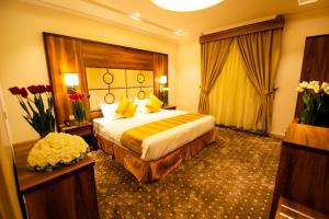 um quarto de hotel com uma cama e flores nele em Hayat Al Rose Hotel Appartment em Jeddah
