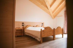 Schlafzimmer mit einem Bett und Holzboden in der Unterkunft Agritur Rizzi di Inama Ugo in Coredo