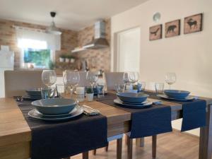 a dining room table with plates and wine glasses at Vila Novaković in Kladovo