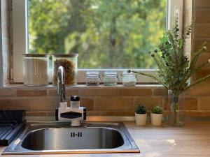 a kitchen sink with a window with a windowtaining at Vila Novaković in Kladovo +23 photos