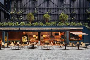 an outdoor dining area with tables and chairs at The Click Clack Hotel Medellín in Medellín