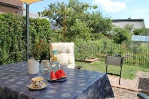a table with a blue table cloth and watermelons on it at FeWoGeestland in Bremerhaven