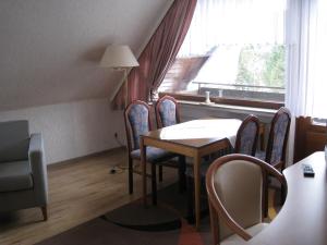 een eetkamer met een tafel en stoelen en een raam bij Appartementhaus Looss in Altenau