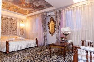 a bedroom with a bed and a table and a ceiling at Hotel General in Ekibastuz
