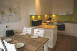a kitchen with a table with chairs and a counter top at FeWo Am See 15A in Klein Wittensee