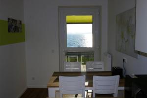 a dining room with a table and chairs and a window at FeWo Am See 15A in Klein Wittensee