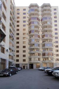 un gran edificio con coches estacionados en un estacionamiento en Argishti street 2 bedroom comfortable apartment in New Building GL933, en Ereván