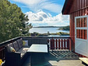 eine Couch auf einer Terrasse mit Blick auf das Wasser in der Unterkunft Apartment EYDEHAVN in Eydehamn