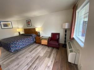 a bedroom with a bed and a chair and a window at Cedar Creek Inn in Bertram
