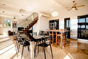 a kitchen and dining room with a staircase and a table and chairs at Casa ChaChaCha in San Juan del Sur
