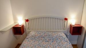 a bedroom with a bed with two lights on it at 616 Genova - Loft al Porto Antico in Genoa