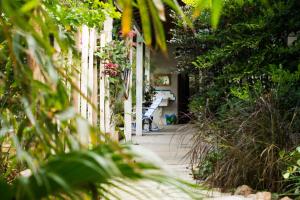 Jardim Secreto Guest House في بوزيوس: شرفة مع سياج أبيض ومقعد