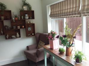 a room with a table with flowers and a chair at The Tollemache Arms in Buckminster