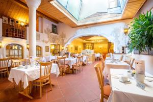 a restaurant with white tables and chairs and a glass ceiling at Hotel Zum Schwarzen Bären in Emmersdorf an der Donau