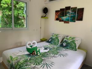 Un dormitorio con una cama con plantas. en Ô TI JACKO en Le Gosier