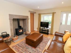 sala de estar con sofá y chimenea en Margaret's Cottage en Feetham