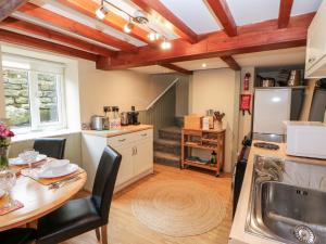 a kitchen with a table and a sink and a counter at Margaret's Cottage in Feetham