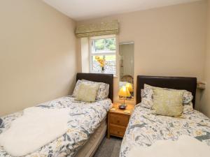a bedroom with two beds next to a window at Margaret's Cottage in Feetham