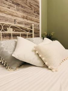 łóżko z białymi poduszkami i drewnianą ścianą w obiekcie Mureșenilor Central Residence w Braszowie