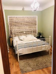 sypialnia z białym łóżkiem z drewnianym zagłówkiem w obiekcie Mureșenilor Central Residence w Braszowie