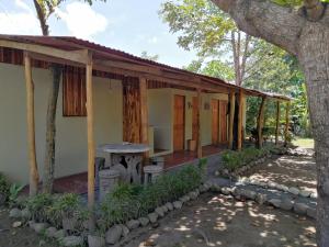 una casa con una mesa y un árbol en El Gecko Hotel & Tours en Paquera