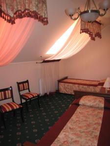a hotel room with two beds and two chairs at Atrium Hotel in Ivano-Frankivsk