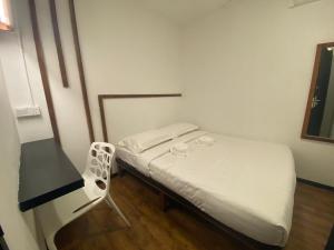 a small bedroom with a bed and a chair at Kuching Hotel in Kuching