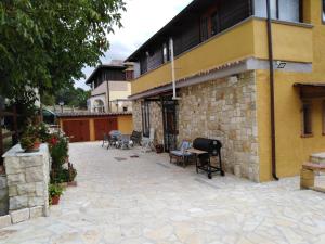 a patio outside of a yellow building with chairs at Villa lalli in Salcito