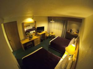 een hotelkamer met 2 bedden en een spiegel bij Cantalagua Inn in Atlacomulco de Fabela