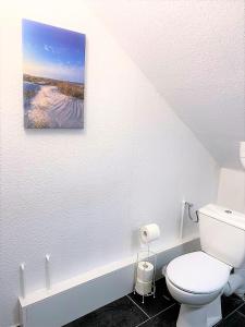 ein Bad mit einem WC und einem Bild an der Wand in der Unterkunft MyHome Basel 3B44 in Saint-Louis