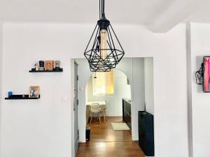 una sala de estar con una lámpara de araña negra colgada del techo en Les Falaises en 'Aïn Taya