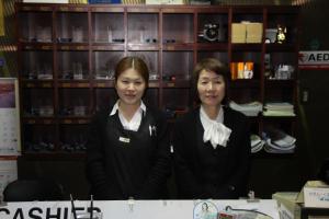 dos mujeres de pie detrás de un mostrador en una tienda en Shingu Central Hotel, en Shingu
