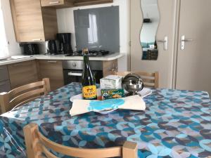 a kitchen with a table with a bottle of wine at CampingKer in Pont-Aven