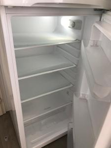 an empty white refrigerator with its door open at CampingKer in Pont-Aven