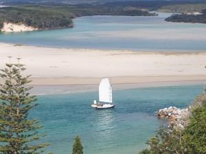 
a sailboat in the middle of the ocean at Forest view bungalow in Nambucca Heads
