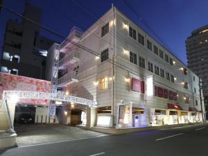 Un edificio bianco con le luci di Natale sul lato. di Hotel Fine Garden Juso ad Osaka