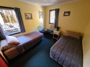 a bedroom with two beds and a window at Chateau Backpackers & Motels in Franz Josef