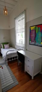 a bedroom with a bed and a desk and a window at Regent Residential Villa in Whangarei