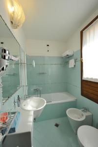 a bathroom with a sink and a tub and a toilet at Hotel Russo Palace in Venice-Lido