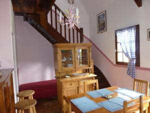 ein Esszimmer mit einem Tisch und einer Treppe in der Unterkunft Les Granges Du Bout De La Ville in Montville