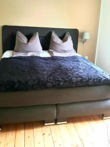 uma cama com almofadas num quarto em Zentrumnahe, moderne Wohnung mit Terrasse em Oldenburg