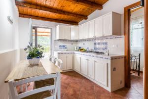 アヴォラにあるVilla degli Uliviの白いキャビネットと木製の天井が備わるキッチン